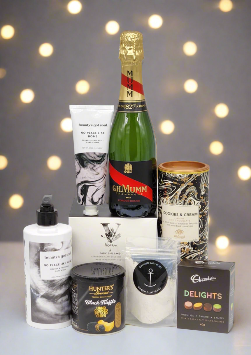 Collection of gourmet items including a bottle of champagne, chocolate, and other products against a blurred light background.