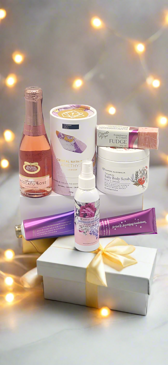 Assorted beauty products on a white surface with string lights in the background