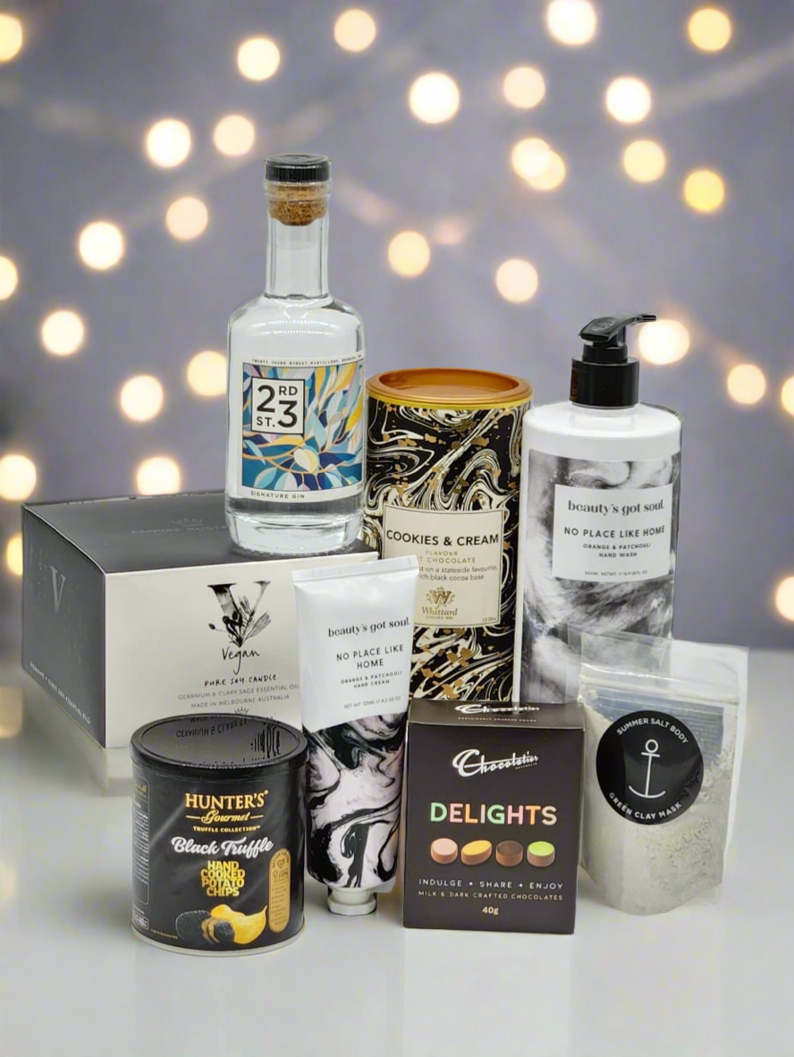 Collection of various products including a bottle, candles, and boxes on a blurred lights background