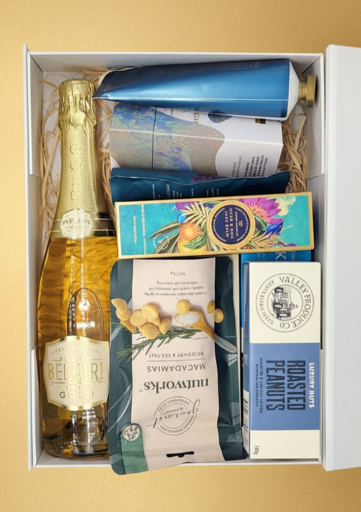 Gift box with a bottle of champagne, chocolate bars, and other items on a gold background